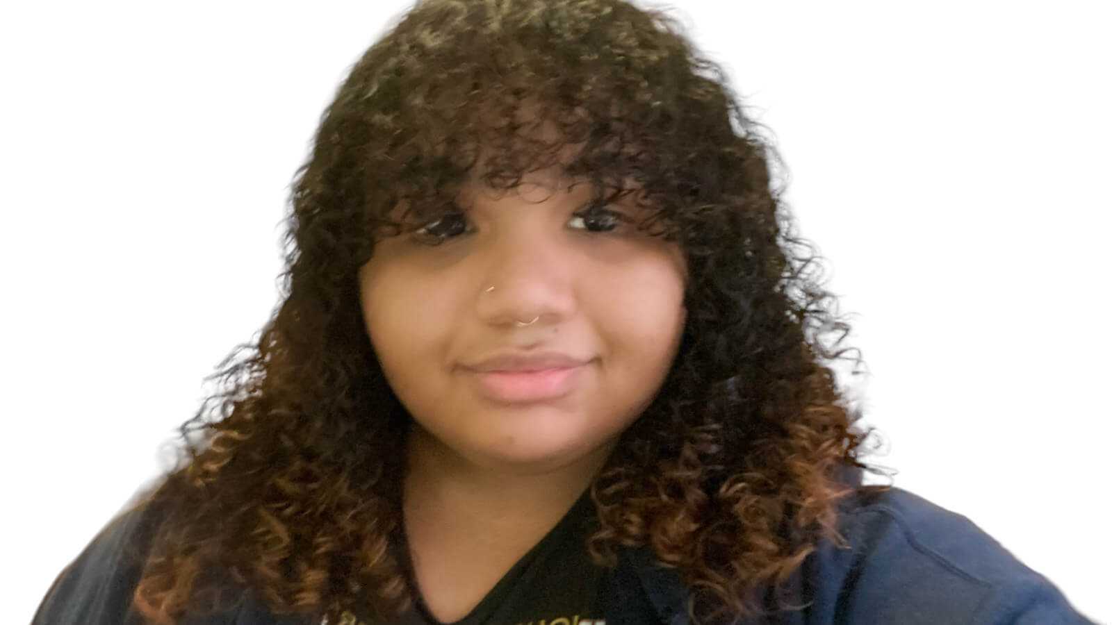 A young woman with shoulder-length curly brown hair smiling against a white backdrop.