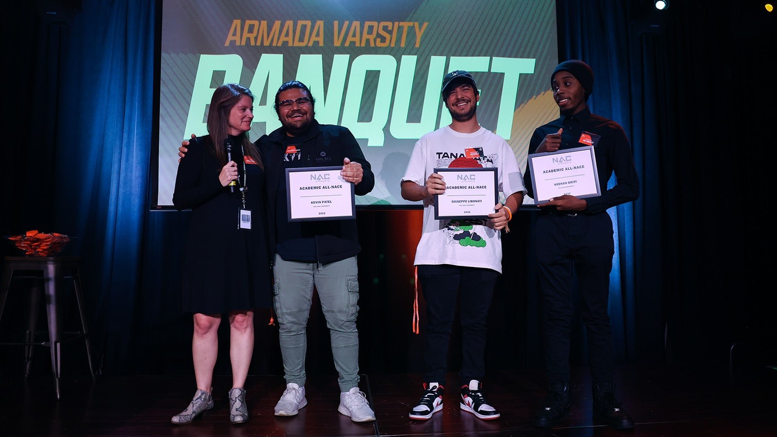 Director of Esports and Project Development, Sari Kitelyn, on stage with the three campus students who received NACE All-Academic awards.